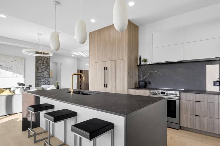 Contemporary kitchen with organic pendant lights and dark stone countertops