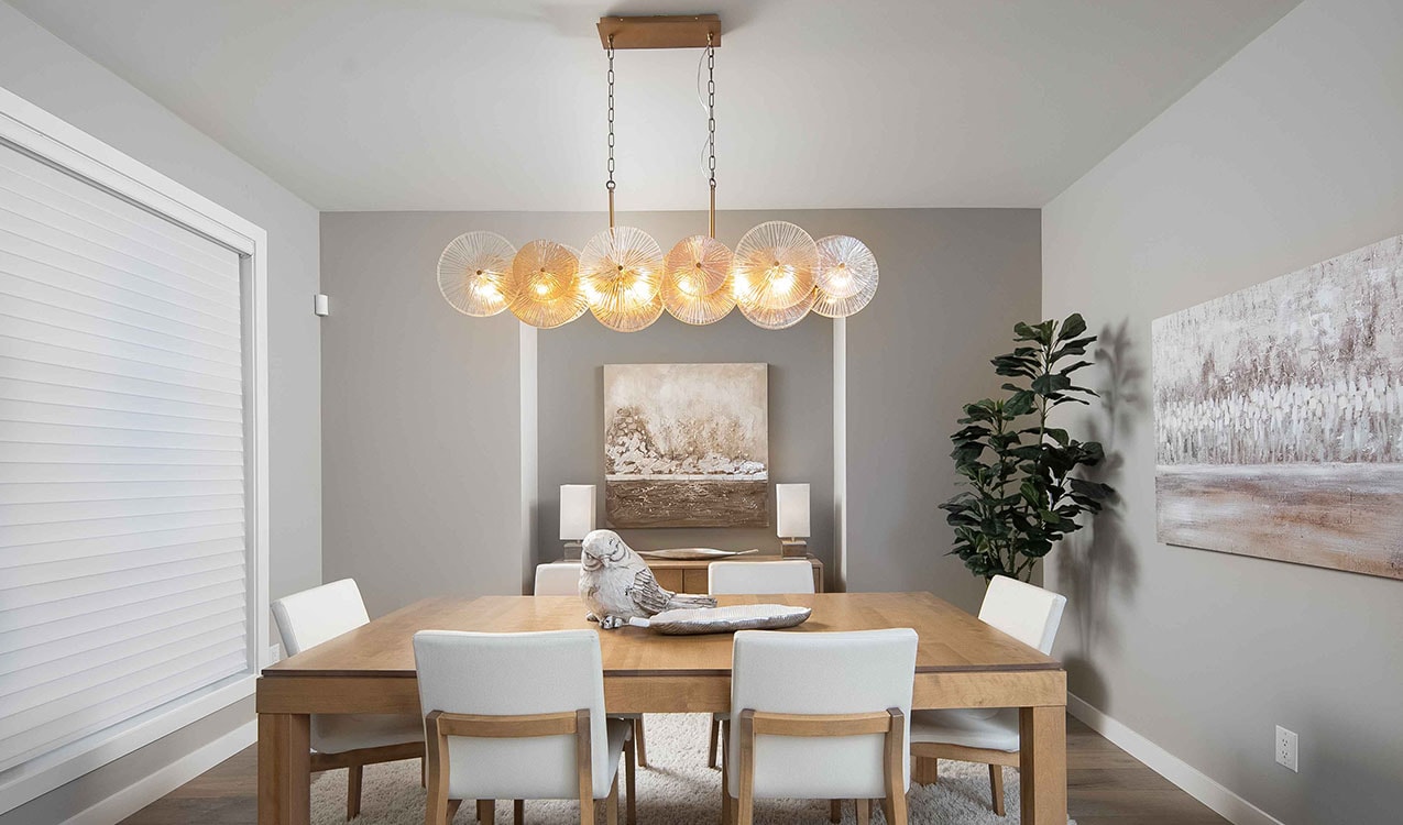 Modern dining room with warm wood tones and a multi-globe brass pendant light
