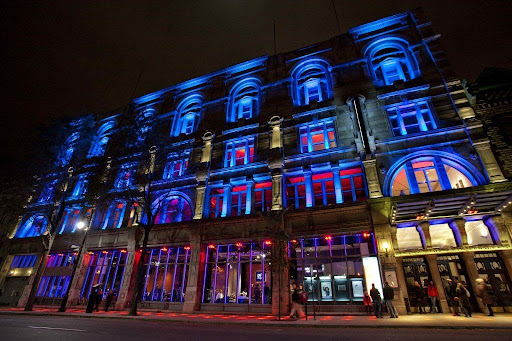 Illuminated historic building facade with blue and red neon lighting